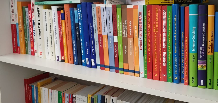 العديد من الكتب الملونة المختلفة على رف في المكتبة