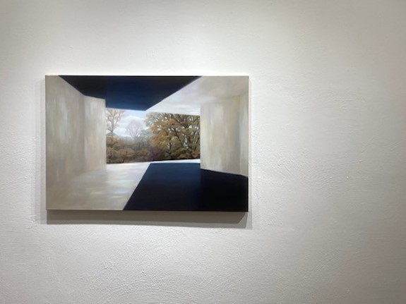 Painting shows a light-coloured, rectangular passageway with shadows looking onto a wooded background with bare trees.