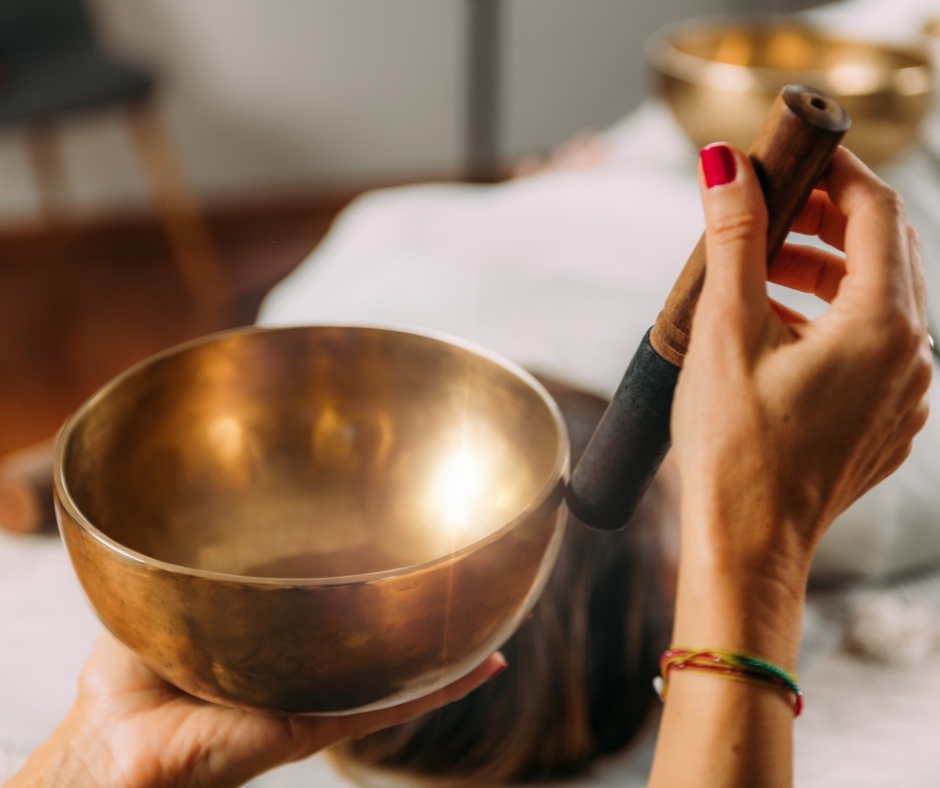 Meditation with a singing bowl One hand holds a mallet and strokes it on the edge of a singing bowl.
