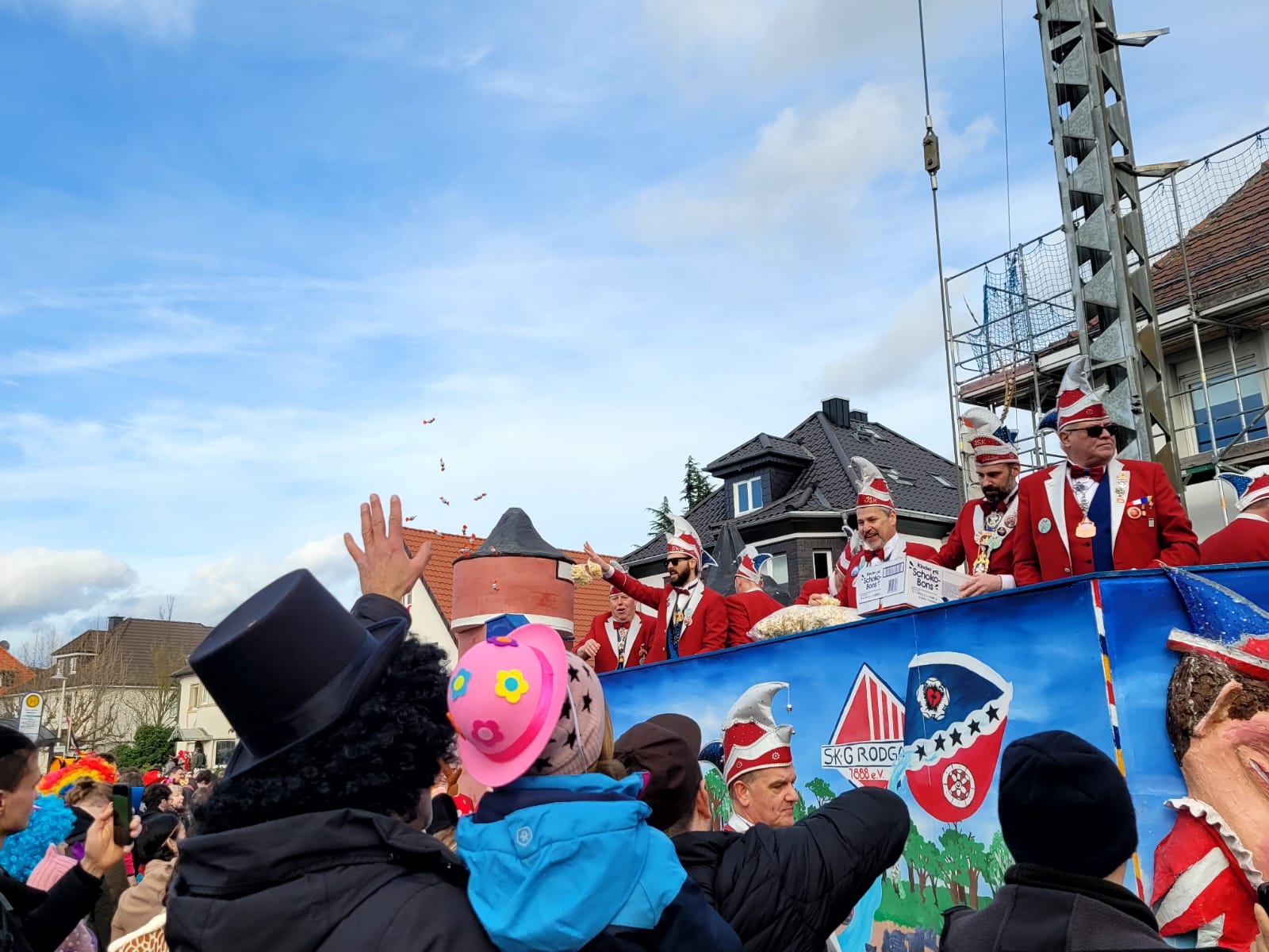 The Elferrat is on a carnival float on Shrove Tuesday and the people standing on the street around it cheer the float and have fun.