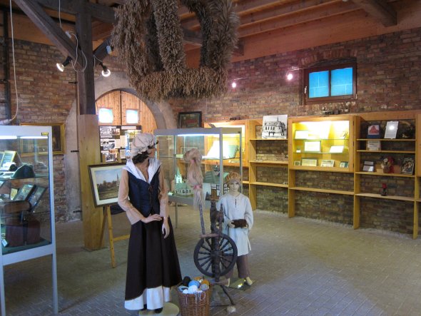 Historical exhibition in the Weiskirchen Museum with figures in traditional clothing and spinning wheel