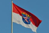 Bandera de Hesse con franjas rojas y blancas y el escudo de armas en el centro contra un cielo azul