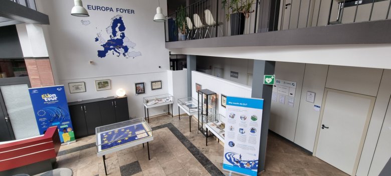 Exposición con temas de la UE en el vestíbulo Europa Exposición sobre temas de la UE en el vestíbulo Europa del ayuntamiento con paneles informativos, vitrinas y un gran mapa de Europa en la pared