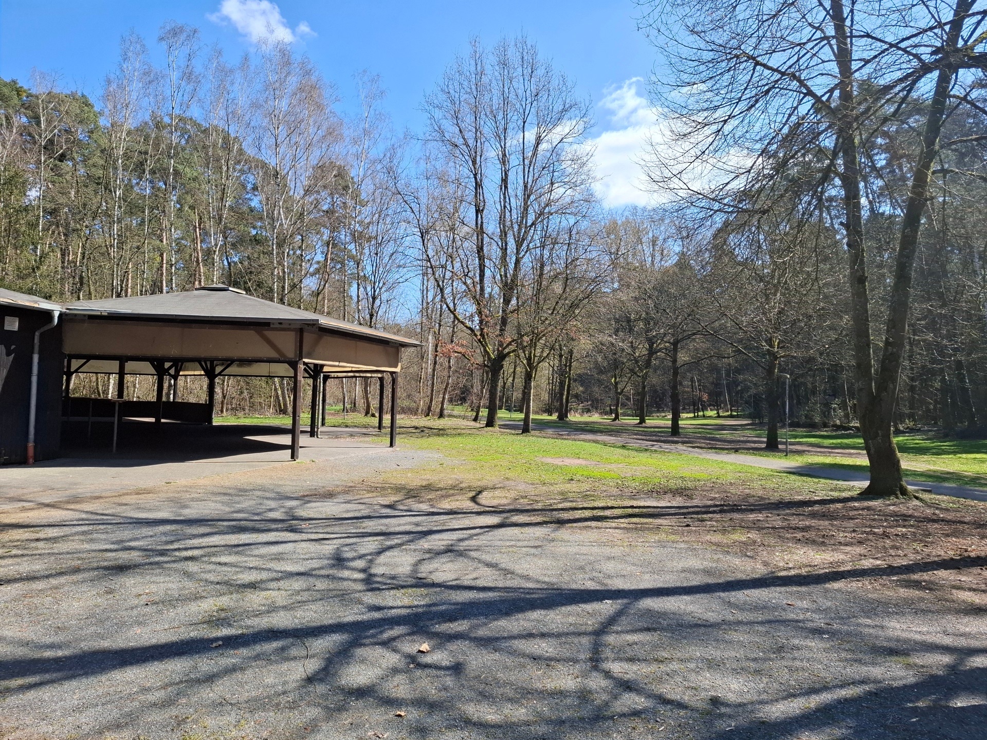 À gauche de l'image, le bâtiment en bois couvert du centre de loisirs forestier, au milieu et à droite, la prairie et la forêt avec vue sur la Gänsbrüh à Dudenhofen.