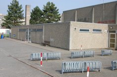 Vista esterna del palazzetto dello sport di Nieder-Roden, circondato da una recinzione e dotato di rastrelliere per biciclette.