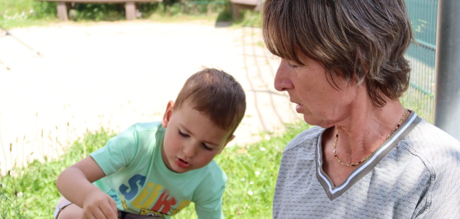 Uczestniczka projektu "Życzliwi dziadkowie" bawi się na świeżym powietrzu na zielonej łące ze swoim "życzeniowym wnukiem".
