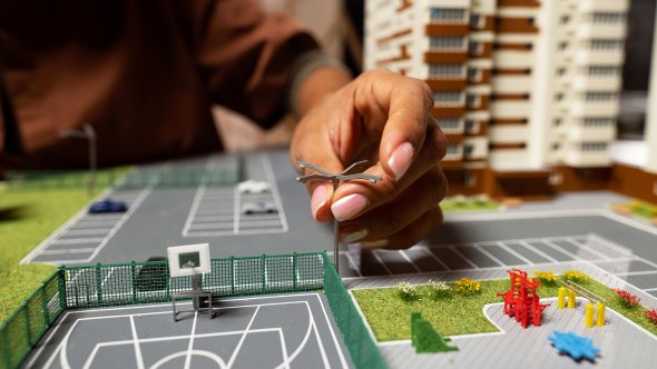 Przekazać miniaturowy model z boiskiem do koszykówki i budynkiem