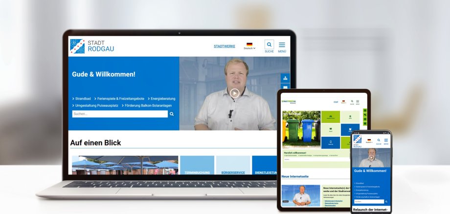 Na jednym stole znajduje się laptop, tablet i smartfon, a na ich ekranach wyświetlane są strony internetowe administracji miasta i zakładów komunalnych.