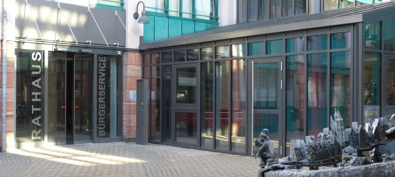 Widok na wejście do centrum obsługi mieszkańców w ratuszu z fontanną na pierwszym planie