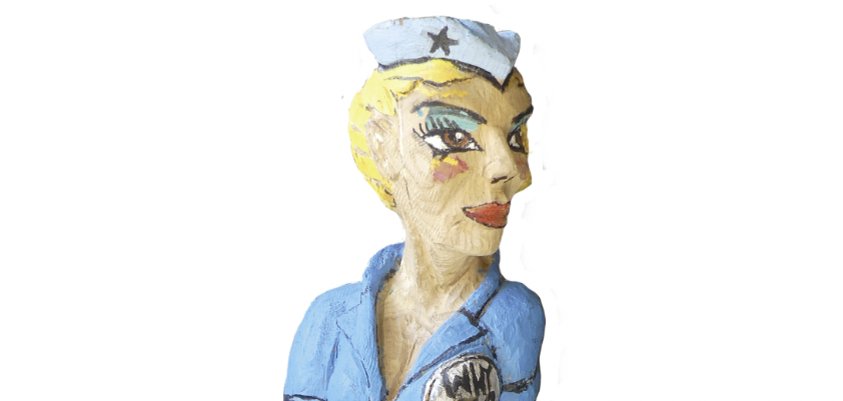 Sculptură reprezentând un pilot așezat în uniformă albastră, pe un avion. Material: stejar roșu, înălțime aprox. 60 cm, an: 2019, inscripție: "Pop-A-Roc".