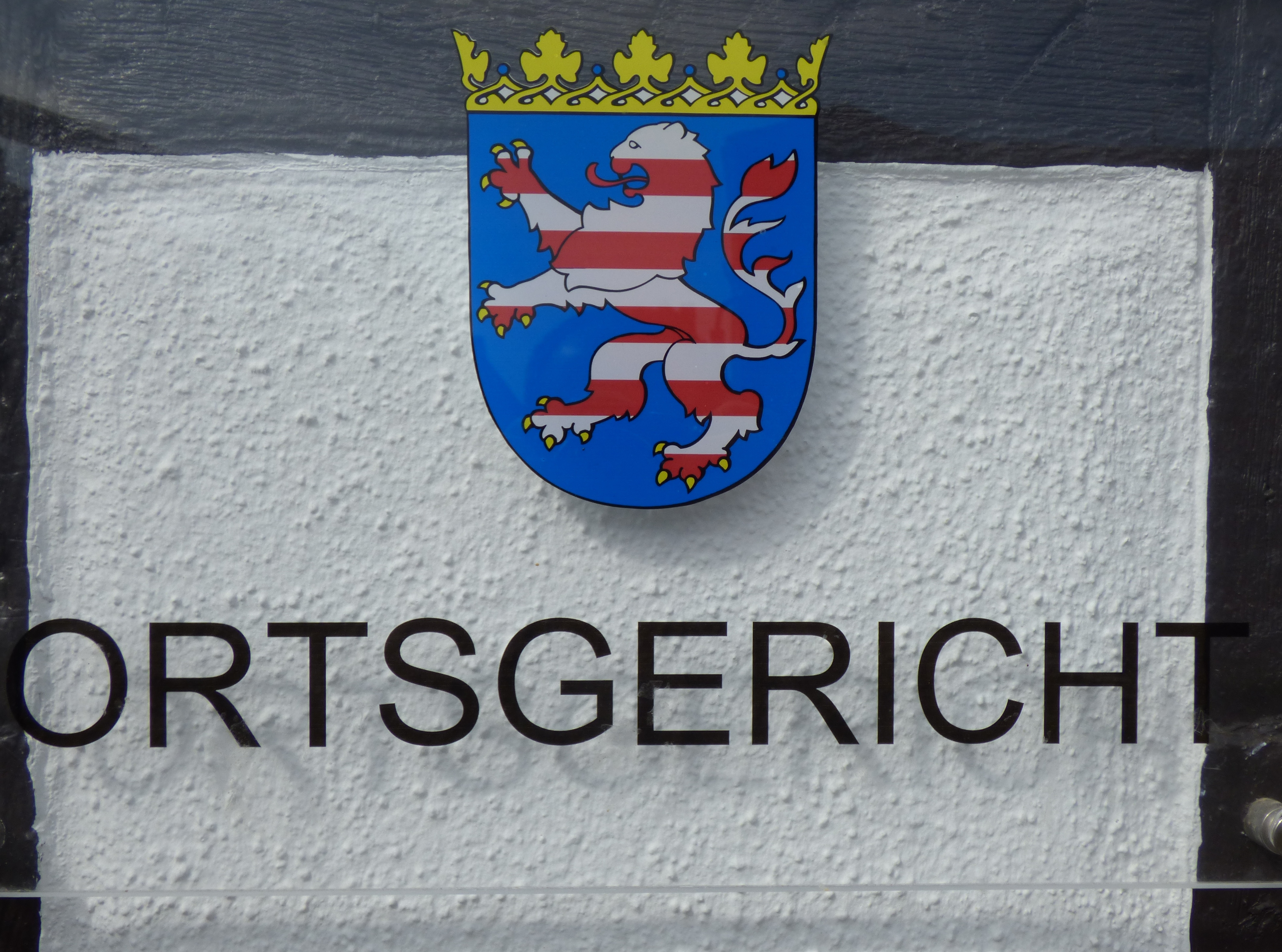 Stema cu leu și coroană deasupra literei "ORTSGERICHT" în Dudenhofen.