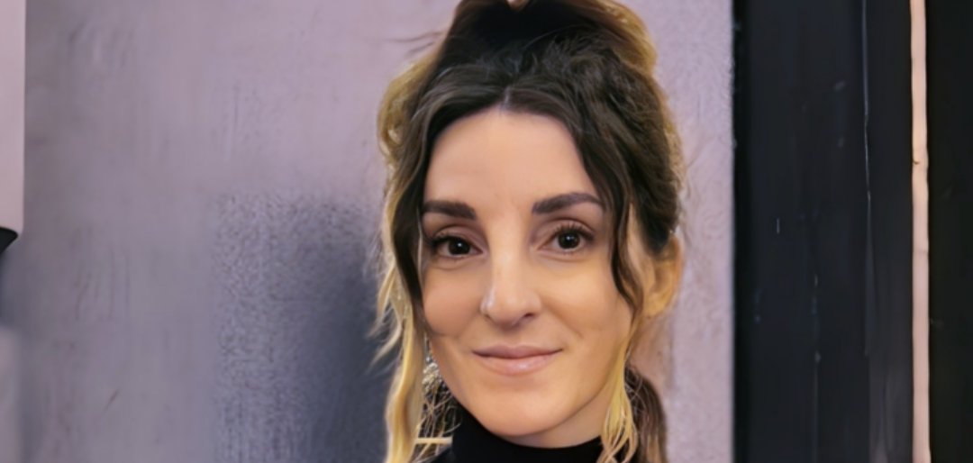 "Sonnwendmord" (Gündönümü Cinayeti) kitabının yazarı Andrea Walter'ı görüyorsunuz. Saçını topuz yapmış ve iki tutamını öne doğru uzatmış. Üstü siyah ve yakalı.