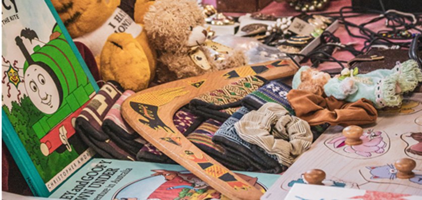 Bir bit pazarında çocuk kitapları, peluş oyuncaklar, tahta oyuncaklar ve takıların bulunduğu masa Bir bit pazarında çocuk kitapları, peluş oyuncaklar, tahta oyuncaklar ve takıların bulunduğu masa