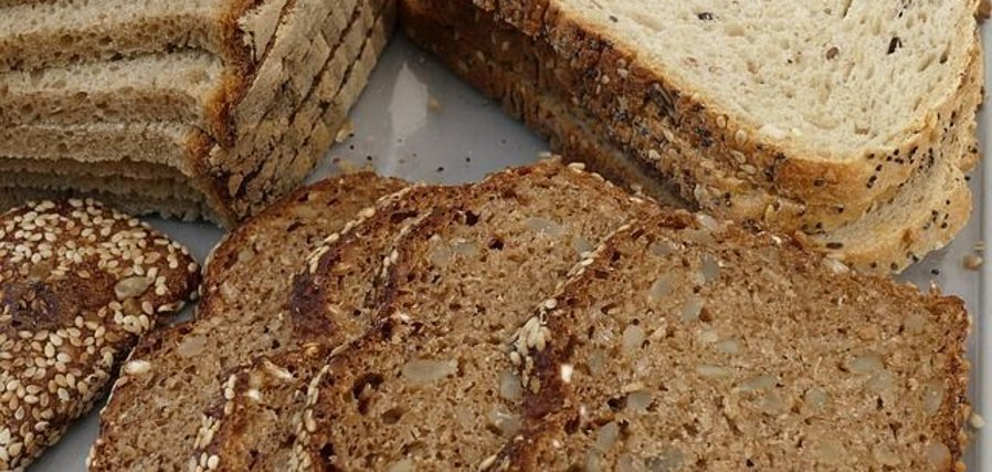 Mehrere Scheiben Vollkornbrot mit Sesam und Sonnenblumenkernen auf einem Teller