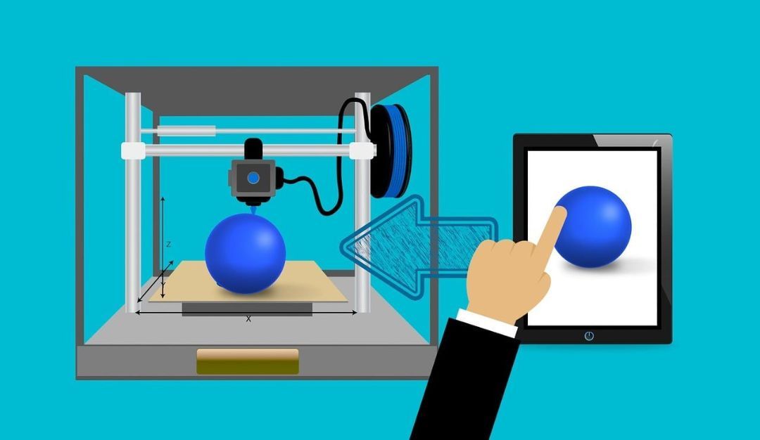3D Druck und CAD 3D-Drucker druckt eine blaue Kugel neben einem Tablet mit einer Hand, die auf eine blaue Kugel auf dem Bildschirm zeigt