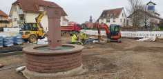 Bauarbeiten im Rahmen des Stadtumbaus Dudenhofen Im Vordergrund ist der Brunnen am Bürgerhaus in Dudenhofen, dahinter ein Bagger und daneben Bauarbeiter