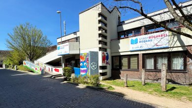 Stadtbücherei Rodgau Außenansicht der Stadtbücherei Rodgau in Niederroden mit Eingangsrampe und bunten Wandmalereien auf der Betonwand