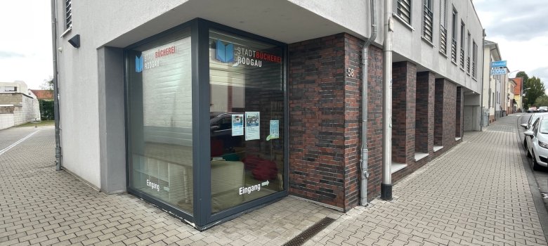 Stadtbücherei Jügesheim Eingang der Stadtbücherei Jügesheim in einem modernen Gebäude mit Glasfront und Hinweisschildern
