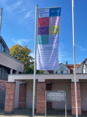 Vielfaltsfahne Vielfaltsfahne mit Aussagen zur Vielfalt in Rodgau, darunter 'Mein Rodgau ist ...', verschiedene Symbole und die Rodgauer Vielfaltserklärung am Bürgermeister-Hermann-Sahm-Platz