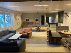 Großer Raum im Jugendhaus Dudenhofen Auf dem Bild ist der große Raum des Jugendhauses im Untergeschoss mit Tischtennisplatte, Kickertisch und Sitzgelegenheiten zu sehen.