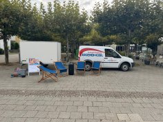 Das Jugendmobil mit Anhänger steht mit Sonnenstühlen auf dem Puiseauxplatz