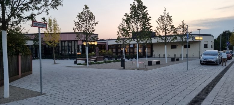 Vorplatz des Bürgerhauses in Dudenhofen mit Bäumen und Autos