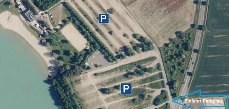 Luftaufnahme von Parkplätzen am Strandbad mit zwei markierten Parkbereichen und Einfahrtsschild 'Einfahrt Parkplatz'