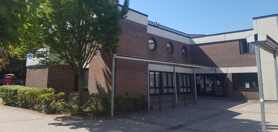 Sozialzentrum Niederroden Eingangsbereich des Sozialzentrums Niederroden mit Backsteinfassade, mehreren runden Fenstern und Bäumen im Vordergrund