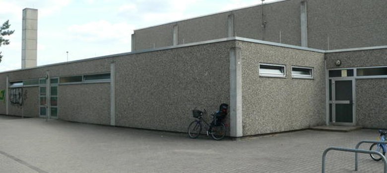 Sporthalle Ansicht der Sporthalle Hainhausen mit einem geparkten Fahrrad davor.