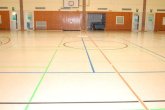 Sporthalle Innenansicht der Sporthalle Jügesheim, ausgestattet mit einem Basketballfeld und einer Bodenmarkierung.