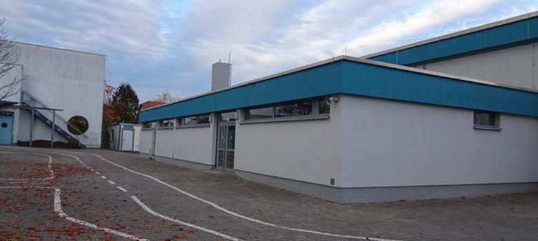Turnhalle Turnhalle der Wilhelm-Busch-Schule, erkennbar an blau-weißem Dach und angrenzendem Pausenhof.