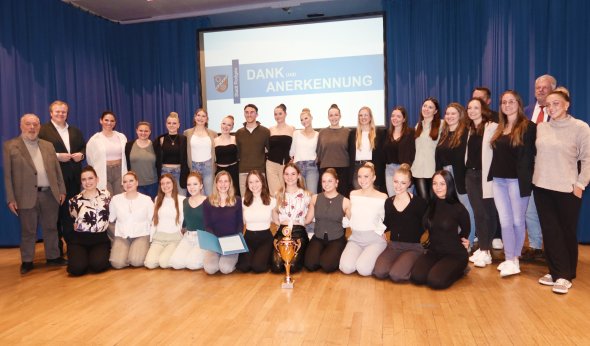 Vereinsgala Eine Gruppe von Menschen posiert für ein Foto vor einem Bildschirm bei der Vereinsgala