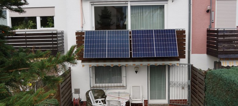Balkonsolaranlagen Sich auf ein weißes Gebäude mit Solaranlage am Balkon