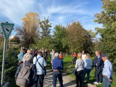 Eine Gruppe von Menschen auf einem Feldweg mit einem Schild des Landschaftsschutzgebietes