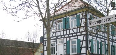 Rektor-Geißler-Haus Garten mit niedriger Backsteinmauer und Bäumen vor dem Fachwerkhaus Rektor-Geißler-Haus mit grünen Fensterläden