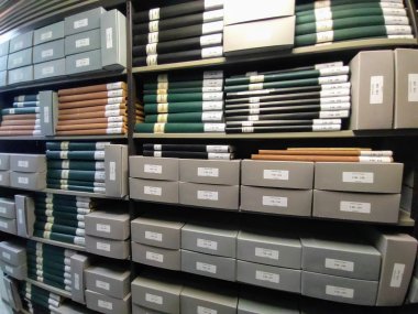 Archivbeständen Regale mit Archivbeständen, gefüllt mit beschrifteten Ordnern und Archivboxen in verschiedenen Farben