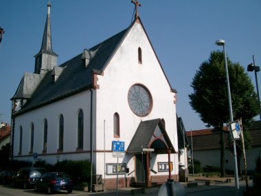 Kirche Hainhausen Kirche in Hainhausen mit spitzem Turm und rundem Fenster an der Fassade
