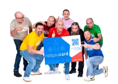 Giesemer Trottwa-Lersche & rodgaucard Die Bandmitglieder der Giesemer Trottwa-Lersche stehen um eine überdimensional-große rodgaucard zeigen auf die Karte oder halten den Daumen hoch.